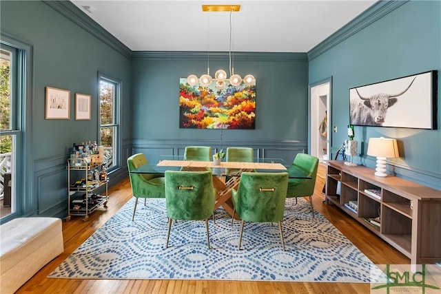 dining space with crown molding, a chandelier, and hardwood / wood-style floors