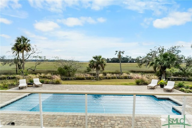 view of pool with a rural view and a patio