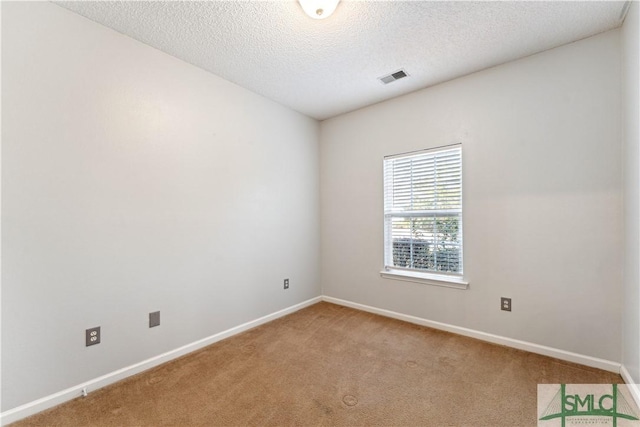 carpeted empty room featuring a textured ceiling