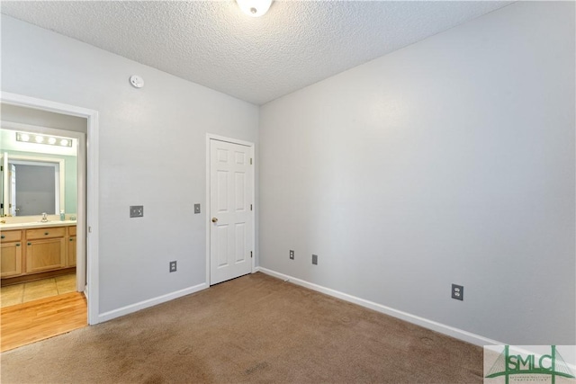 unfurnished bedroom with light carpet and a textured ceiling