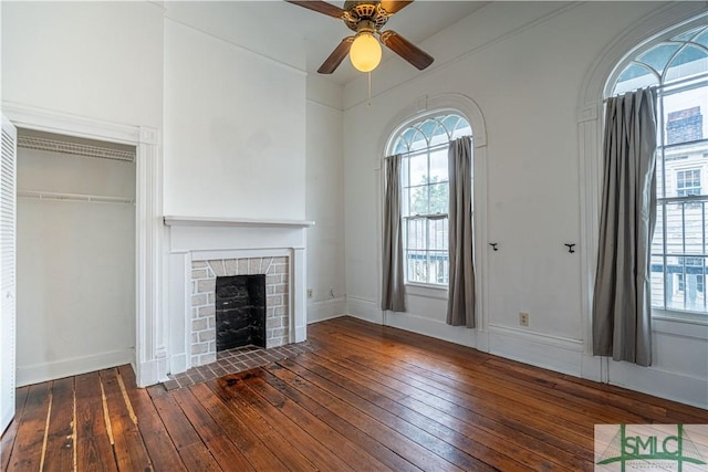 unfurnished living room featuring ceiling fan and dark hardwood / wood-style flooring