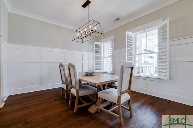 dining room with ornamental molding, a chandelier, and dark hardwood / wood-style flooring