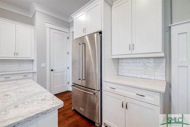 kitchen with high end fridge, white cabinetry, and light stone countertops