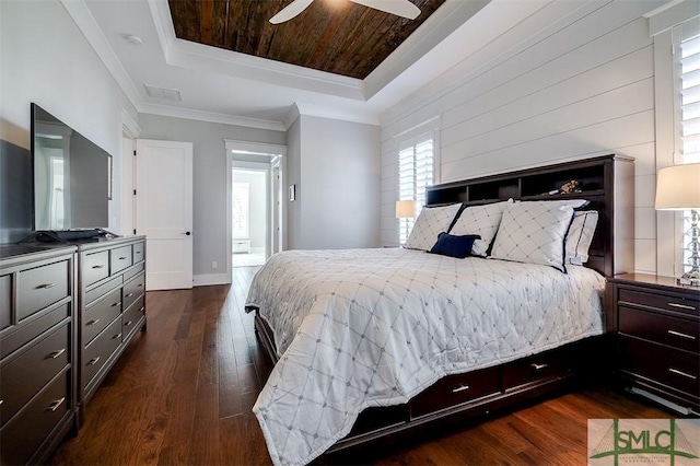 bedroom with dark hardwood / wood-style floors, a tray ceiling, crown molding, and wooden ceiling