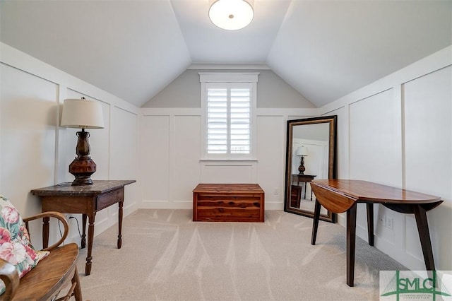 living area featuring lofted ceiling and light carpet