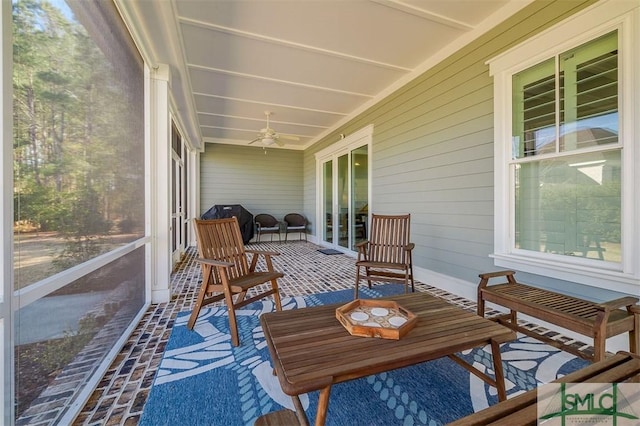 sunroom / solarium featuring ceiling fan