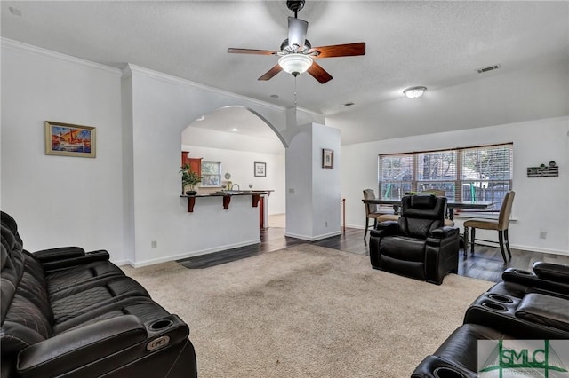 carpeted living room with ornamental molding, a textured ceiling, and ceiling fan