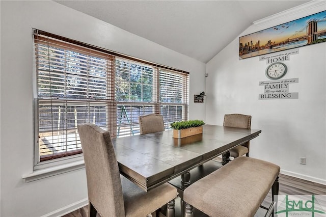 dining space featuring lofted ceiling and wood-type flooring