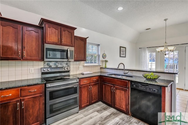 kitchen featuring decorative light fixtures, appliances with stainless steel finishes, sink, and kitchen peninsula