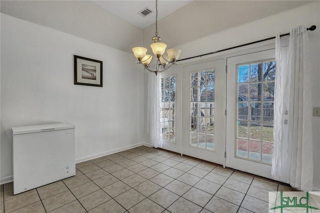 unfurnished dining area with a notable chandelier and light tile patterned floors