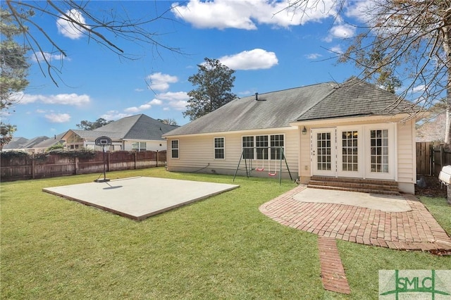 back of property with a patio area and a lawn