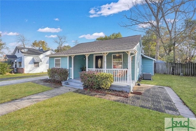 bungalow-style home featuring cooling unit, a porch, and a front lawn