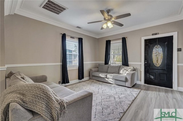 living room featuring light hardwood / wood-style flooring, a wealth of natural light, ornamental molding, and ceiling fan