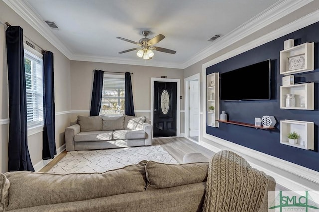 living room featuring light hardwood / wood-style flooring, crown molding, plenty of natural light, and ceiling fan