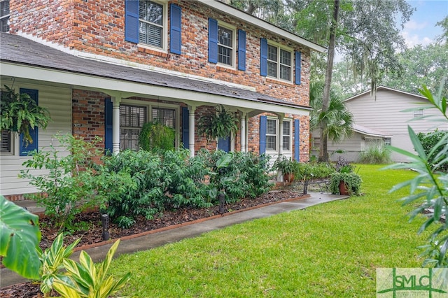 colonial home with a front lawn and covered porch