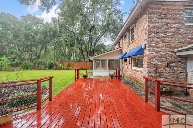 wooden terrace featuring a lawn