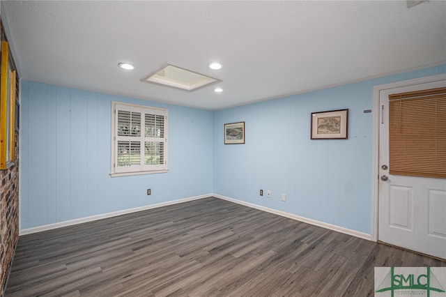 empty room featuring dark wood-type flooring and a textured ceiling