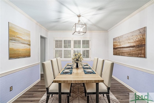 dining space with crown molding, dark hardwood / wood-style floors, and a notable chandelier