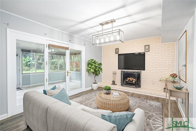 living room featuring a fireplace, wood-type flooring, and ornamental molding