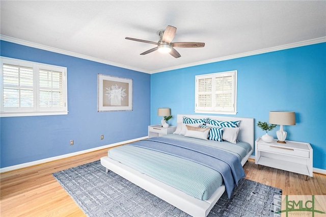 bedroom featuring hardwood / wood-style flooring, crown molding, and ceiling fan