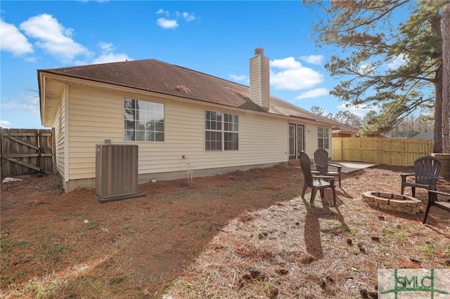 back of property featuring cooling unit, a patio, and a fire pit