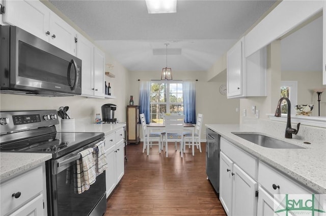 kitchen featuring sink, white cabinetry, hanging light fixtures, stainless steel appliances, and light stone countertops