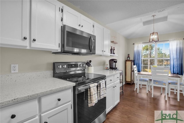 kitchen with pendant lighting, appliances with stainless steel finishes, white cabinetry, dark hardwood / wood-style floors, and light stone counters