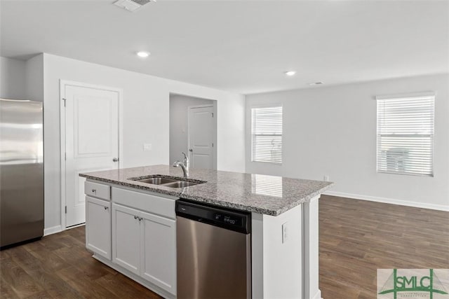 kitchen featuring sink, white cabinetry, a center island with sink, appliances with stainless steel finishes, and light stone countertops