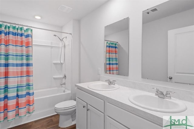 full bathroom with vanity, hardwood / wood-style floors, shower / tub combo, and toilet