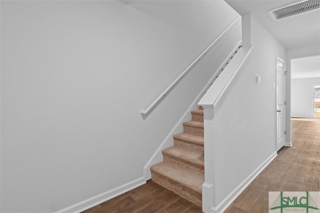 staircase with hardwood / wood-style floors