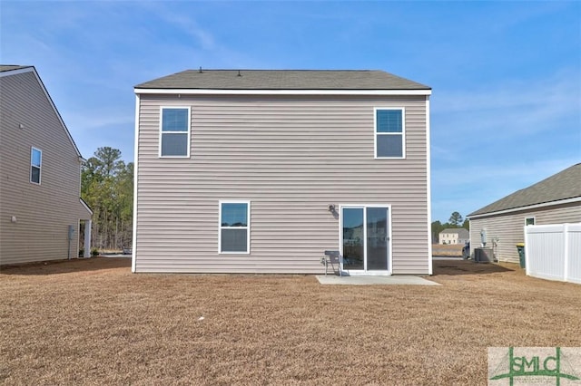 back of house featuring cooling unit, a patio area, and a lawn