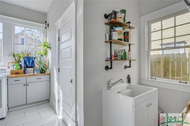 washroom with washer / clothes dryer, sink, and light tile patterned flooring