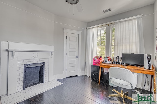 office space featuring a brick fireplace and dark hardwood / wood-style floors