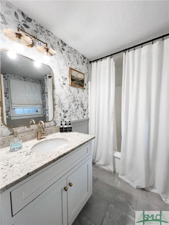 bathroom with shower / tub combo with curtain, vanity, and a textured ceiling