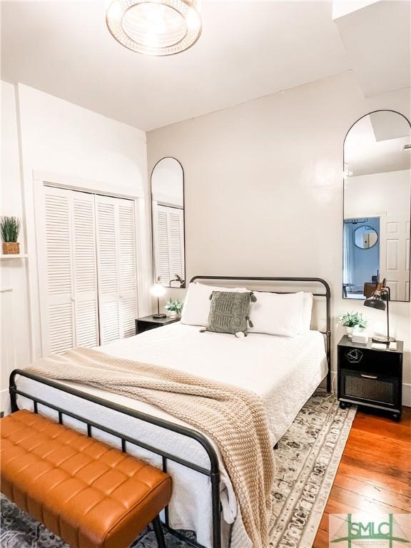 bedroom with wood-type flooring and a closet