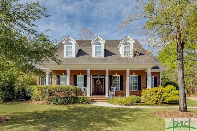 new england style home featuring a front lawn and covered porch