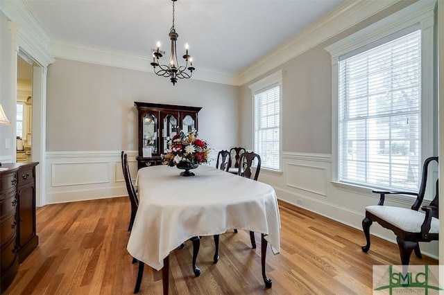 dining area with crown molding, a wealth of natural light, and light hardwood / wood-style flooring