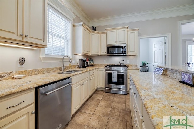 kitchen featuring sink, crown molding, appliances with stainless steel finishes, light stone counters, and cream cabinetry