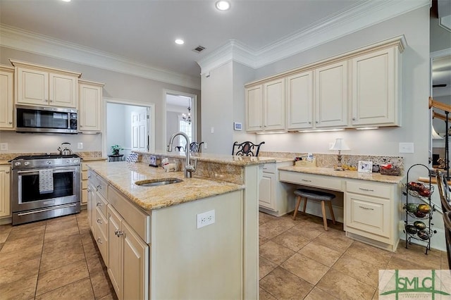 kitchen with sink, light stone counters, stainless steel appliances, a center island with sink, and cream cabinetry