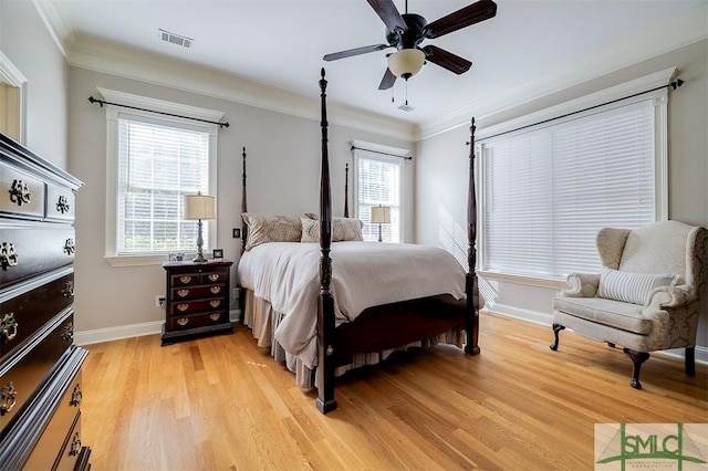 bedroom featuring multiple windows, crown molding, ceiling fan, and light wood-type flooring