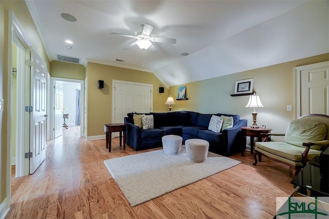 living room featuring ceiling fan, ornamental molding, vaulted ceiling, and light wood-type flooring