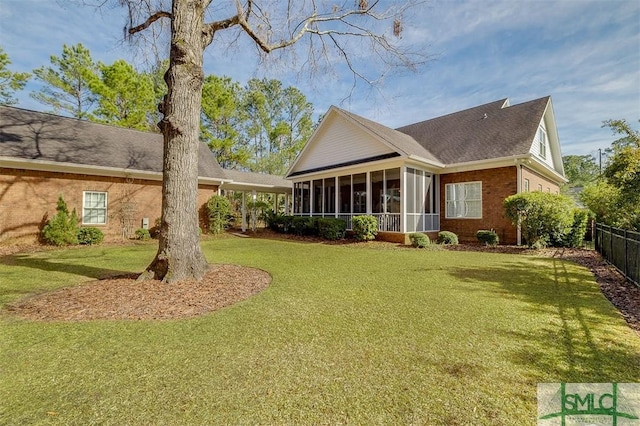 back of property featuring a lawn and a sunroom