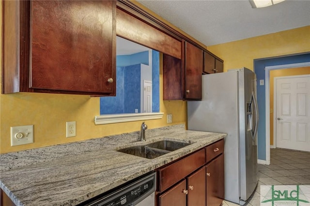 kitchen featuring light stone counters, sink, light tile patterned floors, and appliances with stainless steel finishes