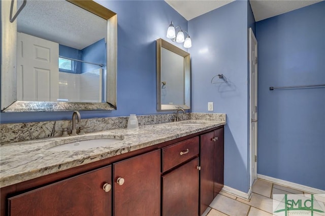 bathroom with walk in shower, tile patterned floors, vanity, and a textured ceiling