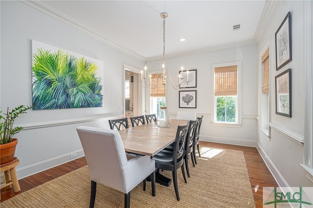 dining space with an inviting chandelier, hardwood / wood-style floors, and ornamental molding