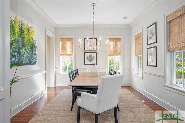 dining area with crown molding, dark hardwood / wood-style flooring, and a chandelier