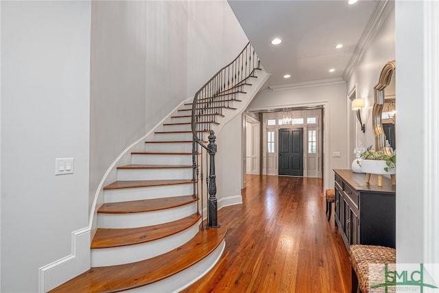 foyer entrance with ornamental molding and dark hardwood / wood-style floors