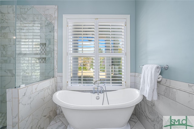 bathroom with tile walls and a tub