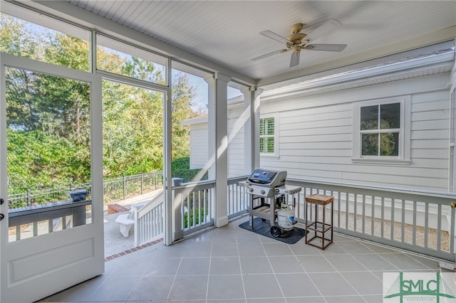 unfurnished sunroom featuring ceiling fan