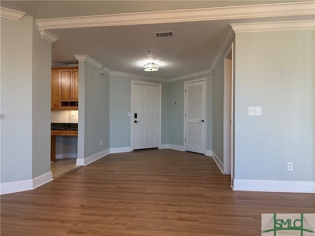 interior space featuring ornamental molding and dark hardwood / wood-style floors